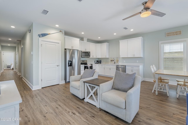 interior space featuring recessed lighting, stainless steel appliances, and white cabinetry