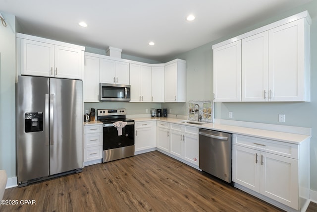 kitchen with a sink, stainless steel appliances, dark wood-style floors, and white cabinets