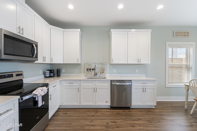 kitchen with a sink, appliances with stainless steel finishes, white cabinets, and light countertops