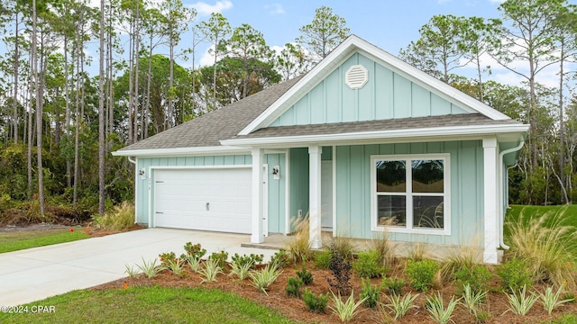 view of front of property with roof with shingles, board and batten siding, an attached garage, and driveway