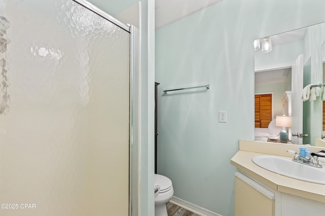 bathroom featuring vanity, an enclosed shower, and toilet