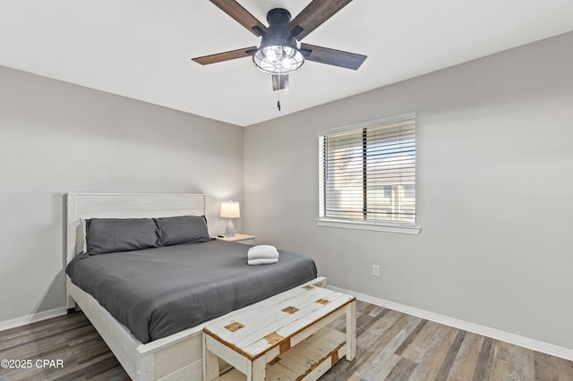 bedroom with dark hardwood / wood-style floors and ceiling fan