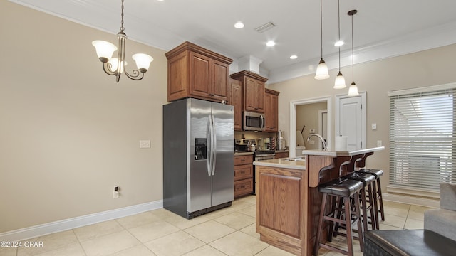 kitchen with a breakfast bar area, stainless steel appliances, a sink, light countertops, and crown molding