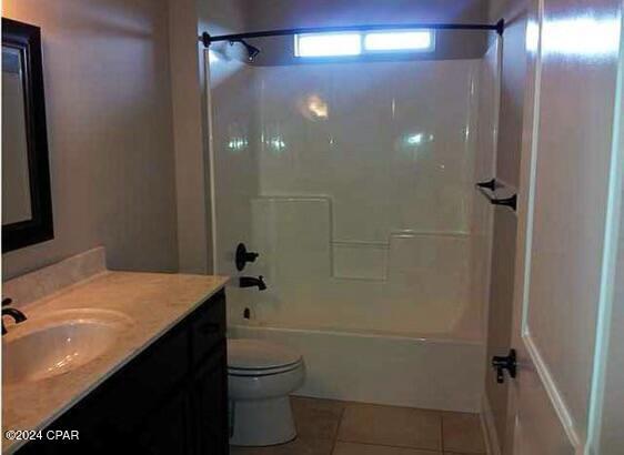 bathroom with shower / washtub combination, vanity, toilet, and tile patterned floors