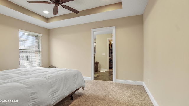 bedroom featuring ceiling fan, recessed lighting, baseboards, a tray ceiling, and carpet