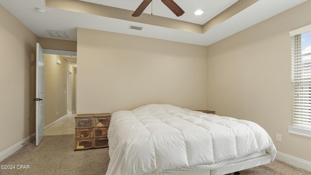 carpeted bedroom featuring baseboards, visible vents, ceiling fan, a tray ceiling, and recessed lighting