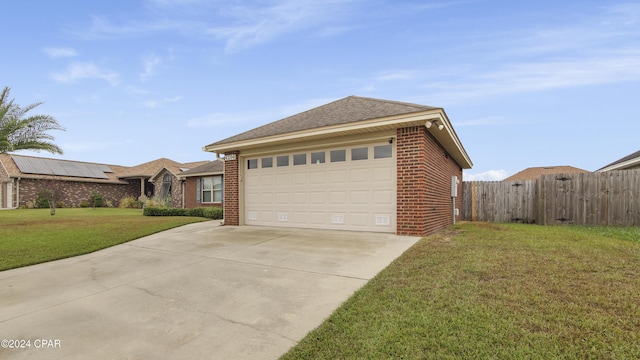 exterior space featuring an attached garage, brick siding, fence, driveway, and a lawn