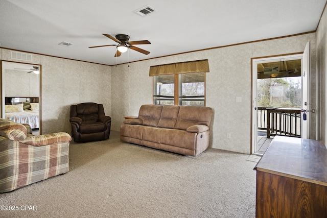 carpeted living area featuring visible vents, a ceiling fan, and ornamental molding
