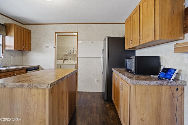 kitchen with dark wood-style floors, stainless steel dishwasher, independent washer and dryer, black microwave, and a textured ceiling