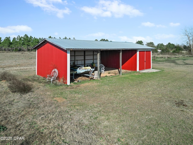view of pole building with a detached carport and a lawn
