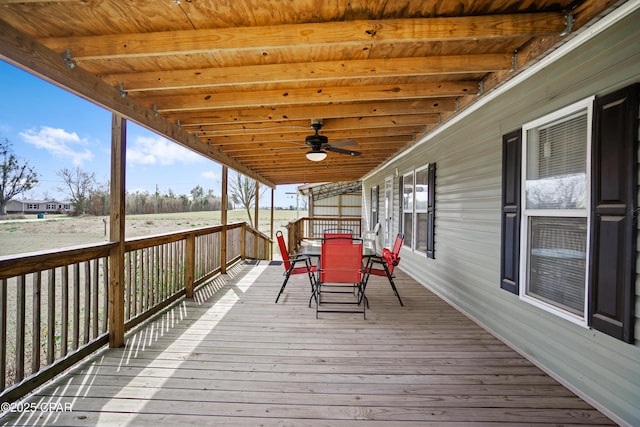 wooden terrace featuring outdoor dining space and a ceiling fan