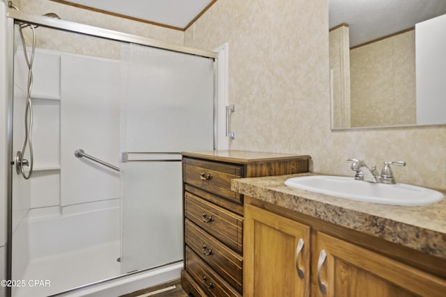 bathroom with vanity, ornamental molding, and a stall shower