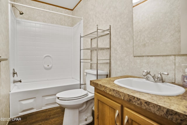 full bathroom with wood finished floors, wallpapered walls, shower / bathing tub combination, vanity, and toilet