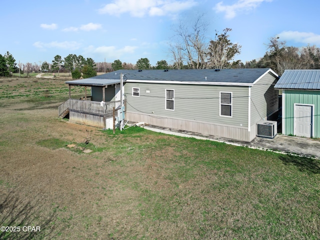 rear view of property with a lawn and central AC unit