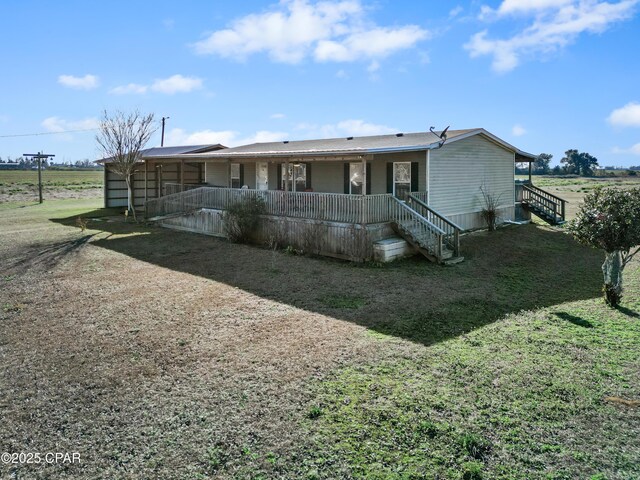 back of house featuring covered porch and stairs