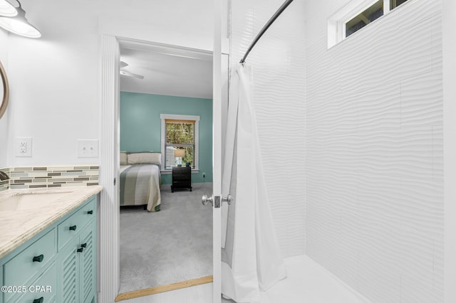 bathroom with a shower with shower curtain, tasteful backsplash, vanity, and ensuite bathroom