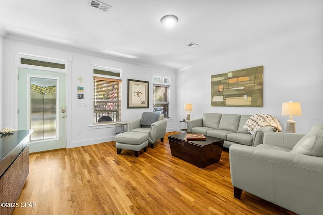 living room with elevator, light wood-style flooring, visible vents, and baseboards