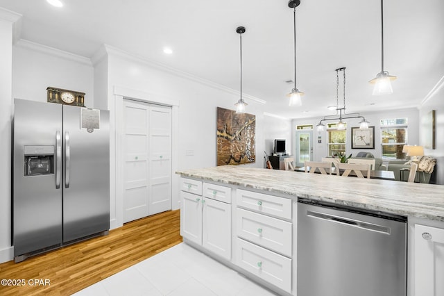 kitchen featuring stainless steel appliances, hanging light fixtures, white cabinetry, and light stone counters