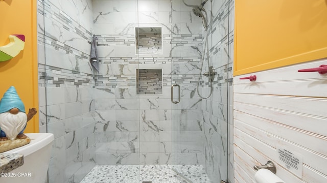 bathroom featuring a stall shower and toilet