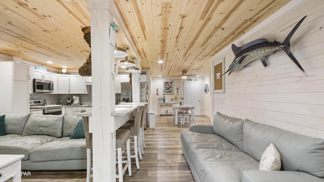 living room featuring recessed lighting, wood ceiling, wood walls, and light wood-style flooring