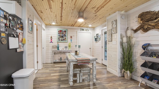 dining area with wood walls, wooden ceiling, wood finished floors, and recessed lighting