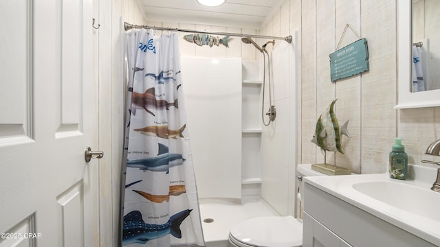 full bath with a stall shower, tile walls, vanity, and toilet