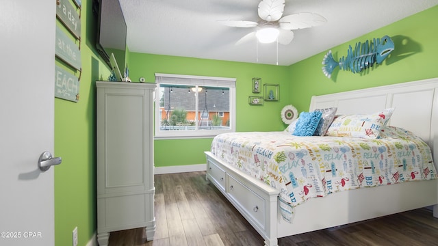 bedroom with ceiling fan, dark wood-type flooring, and baseboards