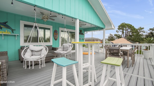 wooden deck featuring outdoor dining space and a ceiling fan