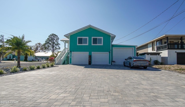 view of front of property featuring a garage, stairs, and decorative driveway