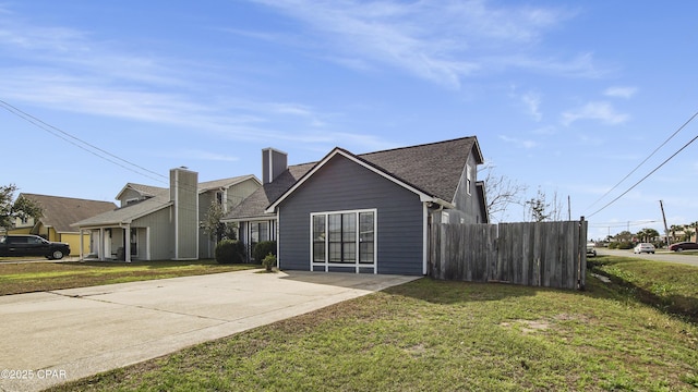 view of front of property with a shingled roof, a front yard, and fence