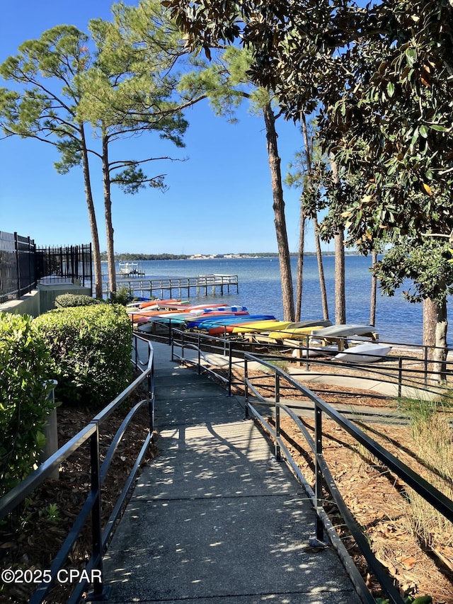 dock area with a water view and fence