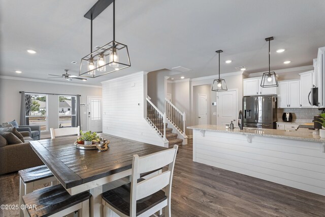 dining area featuring ornamental molding, dark wood-type flooring, stairway, and recessed lighting