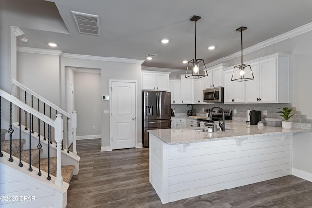 kitchen featuring dark wood-style flooring, visible vents, white cabinetry, hanging light fixtures, and appliances with stainless steel finishes