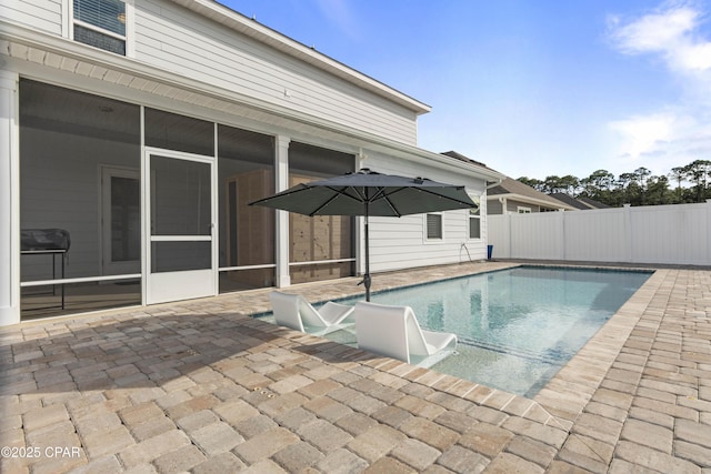 view of swimming pool with a patio area, fence, a sunroom, and a fenced in pool