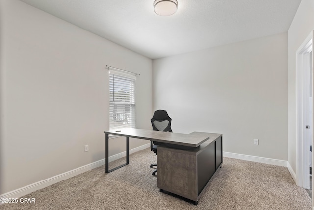 office space featuring baseboards and light colored carpet