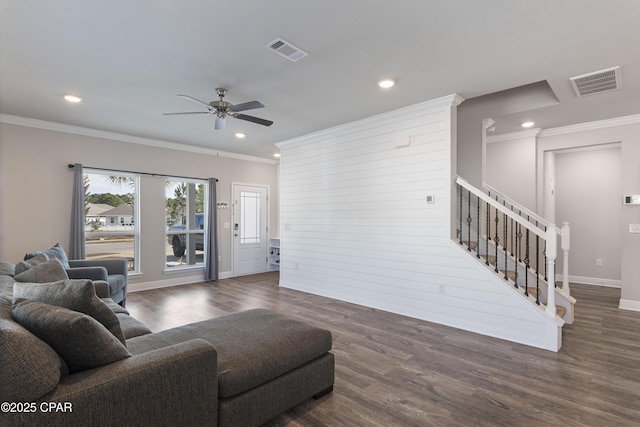 living area featuring dark wood-style floors, stairway, visible vents, and crown molding