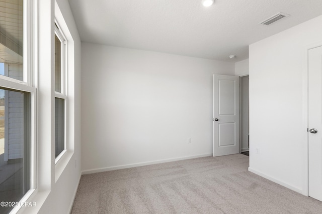 carpeted empty room with a textured ceiling