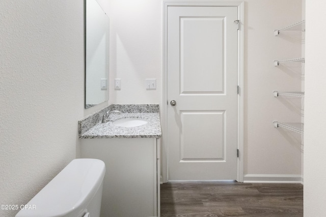 bathroom featuring vanity, hardwood / wood-style flooring, and toilet