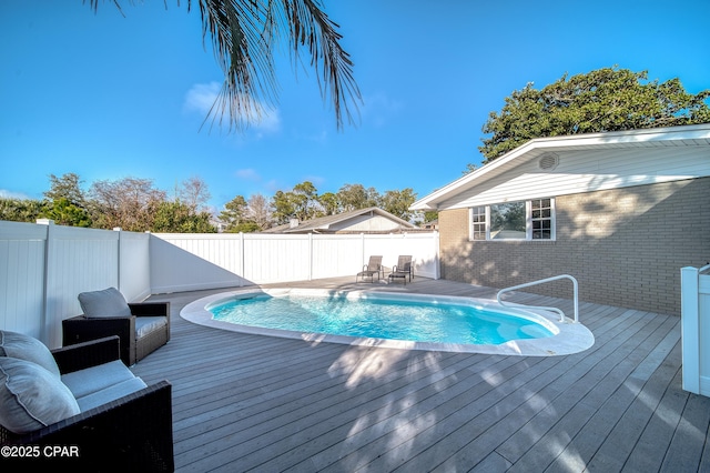 view of swimming pool featuring fence, a deck, and a fenced in pool