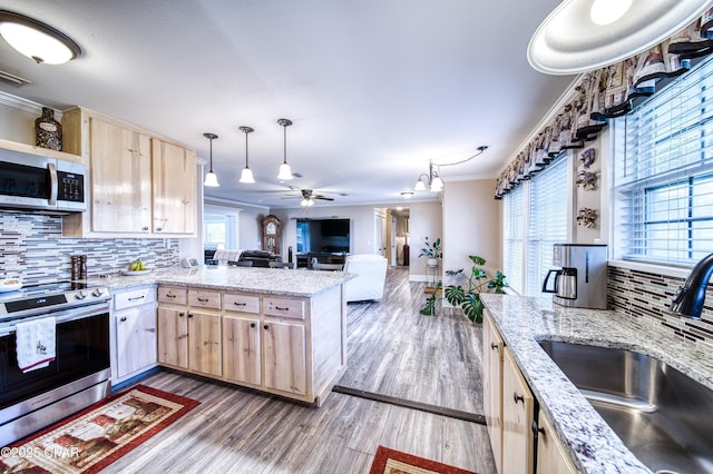 kitchen with sink, crown molding, appliances with stainless steel finishes, hanging light fixtures, and light brown cabinetry