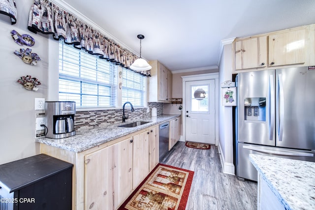 kitchen featuring pendant lighting, sink, stainless steel appliances, and light brown cabinets