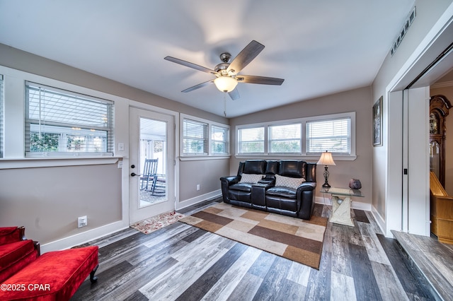 living room featuring ceiling fan and dark hardwood / wood-style floors