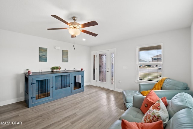 living area featuring a ceiling fan, recessed lighting, baseboards, and wood finished floors