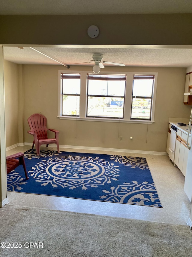 8730 Thomas Dr Unit 1209C, Panama City Beach, FL 32408 - sitting room with healthy amount of natural light, light colored carpet, a textured ceiling, ceiling fan, and baseboards