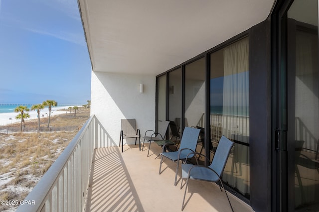 balcony with a beach view and a water view