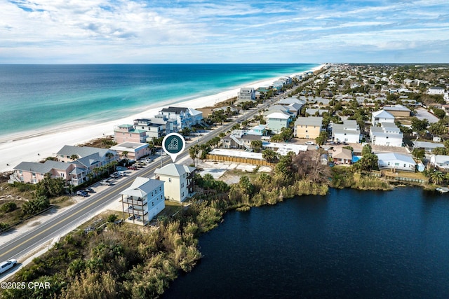 drone / aerial view featuring a residential view, a water view, and a beach view