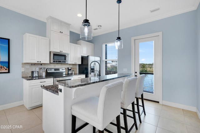 kitchen featuring appliances with stainless steel finishes, a kitchen island with sink, and white cabinets