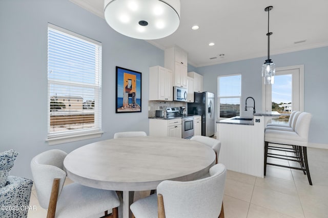 dining area with light tile patterned floors, recessed lighting, a wealth of natural light, and crown molding