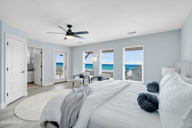 bedroom featuring access to exterior, light wood-type flooring, multiple windows, and visible vents