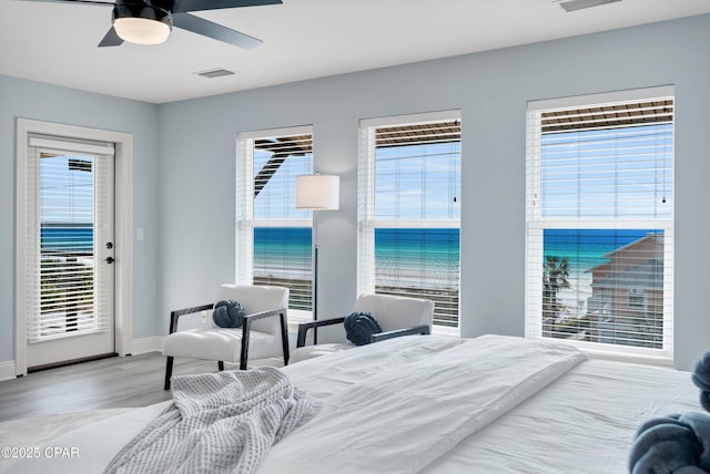 bedroom featuring access to exterior, visible vents, light wood-style floors, multiple windows, and baseboards